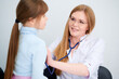 © khmelev - Cheerful female doctor checking patient little girl by stethoscope in hospital
