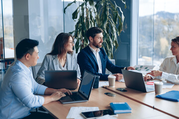 Wall Mural - Corporate business team and manager in a meeting room at modern office with panoramic windows. Business concept