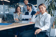 © Yaroslav Astakhov - Smiling confident businesswoman sitting on meeting in office with her colleagues at background. Business concept