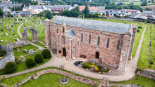 Aerial View Of The Coldingham Priory Church Surrounded By Graveyards In Scotland, United Kingdom