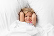 © Lisa Tichané - Happy toddler snuggling on white bed
