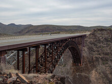 An Arched Bridge Spanning A Rugged Canyon In Arizona