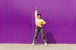 © Dani D.G - Full body of a young woman dancing outdoors with a purple background and yellow clothes. Concept of music, dance, hip hop, trap, reggaeton, alternative, pop, rock.