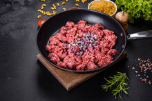 Fresh Raw Mince With Spices And Herbs On A Dark Concrete Background