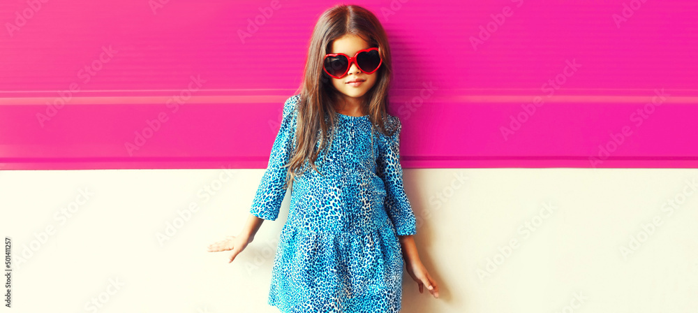 Portrait of beautiful little girl child wearing blue dress on pink ...