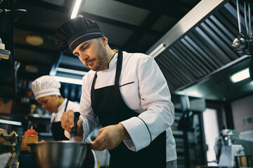 Wall Mural - Professional male cook preparing food at restaurant kitchen.