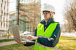 © Shi  - Industrial engineer woman in working uniform connected with PC laptop standing at the construction site.