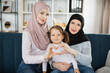Portrait of smiling three generations of muslim women have fun posing for self-portrait picture make heart gesture, happy overjoyed little girl make selfie with young mom and senior grandmother