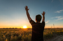 Man Enjoy Life With Raised Hands Against The Sky