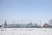 Selective Blur On Neglected And Abandoned Soccer Goals With Football Nets On Display On A Playground Used As A Soccer Field In Bavaniste, Serbia, Covered With Snow During A Cold Winter Afternoon....