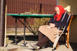 Defocus ukrainian elderly woman in red shawl with crutches sleeping outside. Woman 90 years old. Sick and homecare. Out of focus
