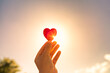 hands holding heart up to the sunlight 