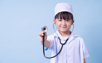 Image of Asian child wearing doctor uniform on blue background