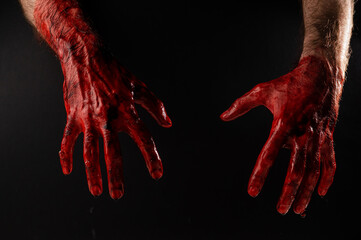 Fototapeta male bloody hands on a black background. 