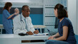 © DC Studio - Male doctor having conversation with mother at examination appointment, taking notes on clipboard papers to give prescription medicine as recovery treatment. Medic and parent talking