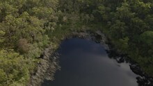 Dense Thicket Surrounds Blue Lakeshore At North Stradbroke Island In Queensland Australia. Aerial Drone Shot