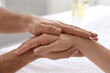 © New Africa - Woman receiving hand massage in wellness center, closeup