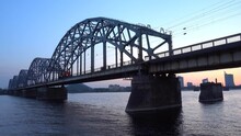 A Shunting Engine Travels Across The Railway Bridge In Riga. Dusk