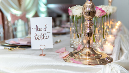 Wall Mural - Set table for a wedding ceremony with decorations of candles and flowers with a Head Table sign