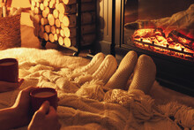Couple In Knitted Socks Near Fireplace At Home, Closeup