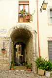 Street between old medieval stone buildings of a historic town in Lazio region, Italy