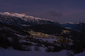 Wall Mural - Photo of houses and mountains in snow in Falera, Surselva, Switzerland by night