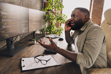 Profile side view portrait of attractive worried guy top manager calling client analyzing project data at workplace workstation indoors