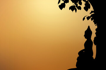 Wall Mural - Silhouette buddha statue sitting under the Bodhi tree.