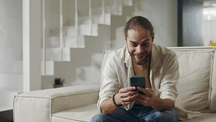 Amazed man saying wow while getting good news on mobile