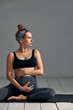 © Georgii - Young pregnant millennial woman sitting on the mat touches her belly after performing prenatal and meditation exercises at a yoga class - Concept of life and maternity