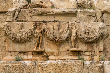 Wall Mural - Myra Ancient City. Preserved bas-reliefs with floral ornaments and faces. Demre, Antalya, Turkey