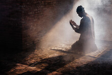 Silhouette Of Muslim Man Having Worship And Praying For Fasting And Eid Of Islam Culture In Old Mosque With Lighting And Smoke Background