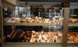 showcase of pastry shop selling dessert cannoli, cakes and pies with price tags through display glass window, a lot of pastries in shop