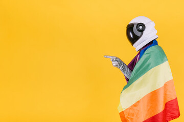 gay man dressed as an astronaut with a helmet and silver suit, with a flag of the lgtbi collective, 