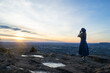 © Lydia - Woman standing on mountain with hands cupped to face