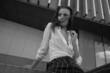 © Yevhen - A young brunette girl in white shirt and striped trouser is sitting on the stairs