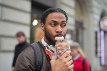 Young Man Eats Some Bread In The Street