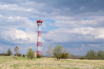 Telecommunication tower of 4G and 5G cellular. Macro Base Station. 5G radio network telecommunication equipment with radio modules and smart antennas mounted on a metal against cloulds sky background.