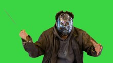 Insane Maniac In Metal Mask With Man Eyes Slaughter Victim With Machete Knife Angry Madman Fighting On A Green Screen, Chroma Key.