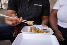 Close Up Man With Chopsticks Eating Takeout Potstickers