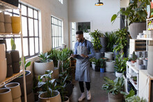 Male Plant Shop Owner With Digital Tablet Checking Inventory