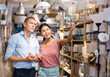 © JackF - Asian woman and European man choosing lamps in furniture store together.