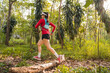 © EduLife Photos - Rearview of adult Asian woman trail runner with running vest practices trail running in the forest park