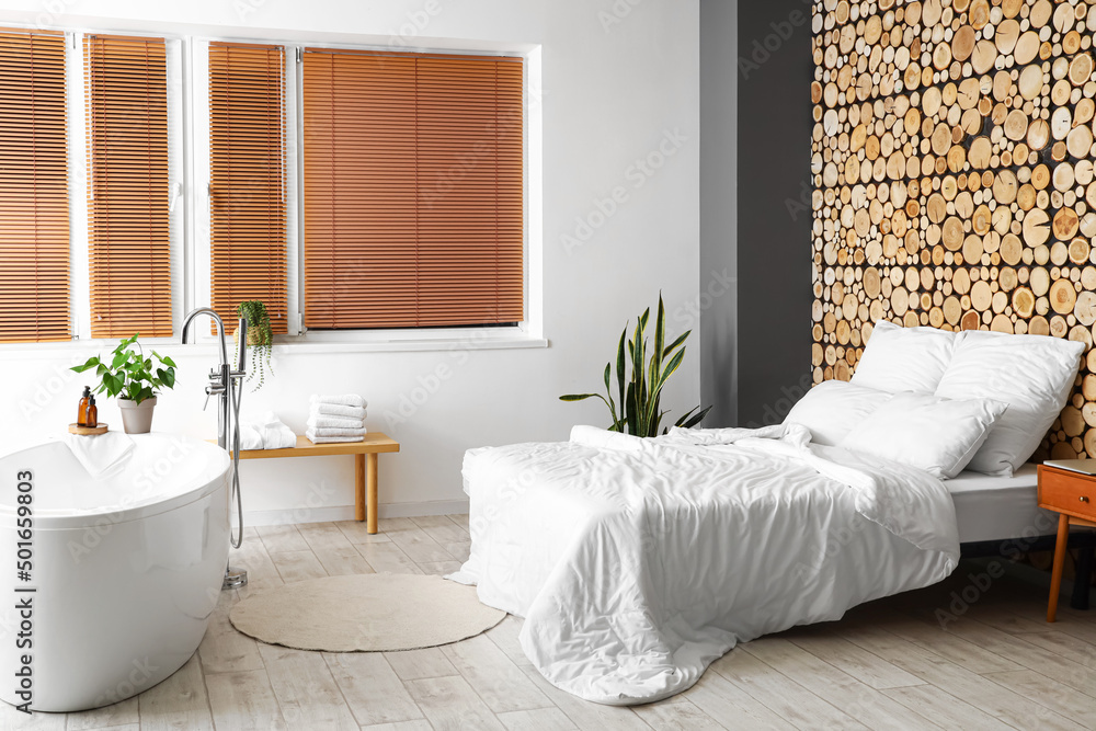 Stylish interior of bedroom with bathtub