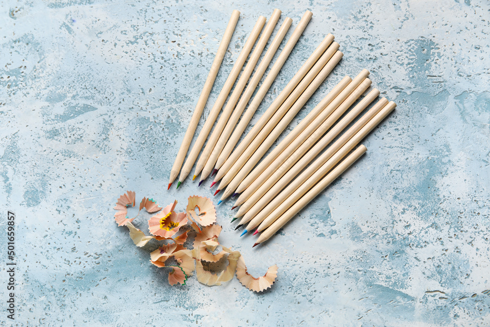 Colorful pencils and shavings on blue grunge background
