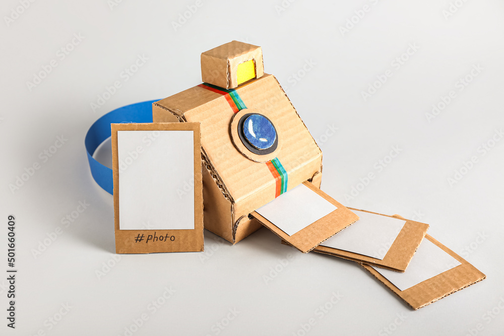 Cardboard photo camera with pictures on light background