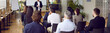 canvas print picture Audience at conference hall. Rear view of people on business training listening to male coach who lectures and trains staff. Business and entrepreneurship concept. Banner. Panorama.