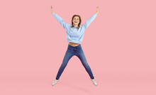 Yes. Hooray. Happy, Confident, Free, Inspired Young Woman In Comfortable Wear Jumping On Pastel Pink Background. Full Body Shot Joyful Positive Carefree Pretty Teen Girl Feeling Ecstatic About Weekend