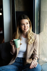 Wall Mural - Young businesswoman drinking coffee in her office