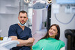 © DusanJelicic - Photo of smiling dentist and patient up in dentist office.